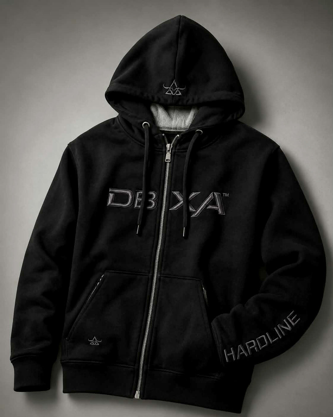 Black DBXA Ironveil zip hoodie with metallic chest embroidery, hood detail and HARDLINE sleeve branding.