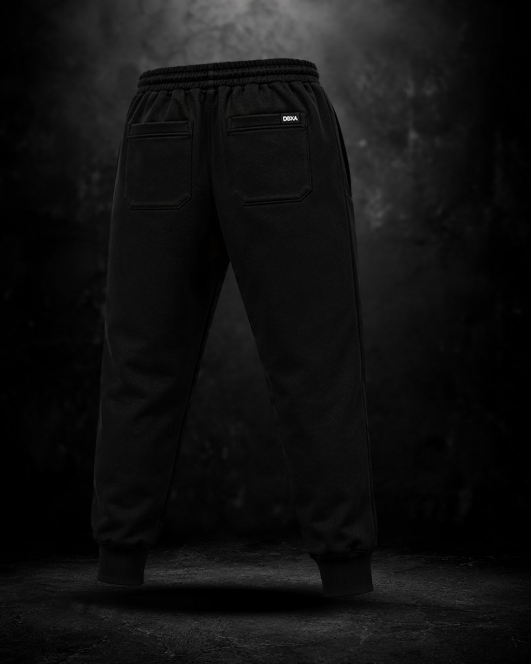 Black pants with a brand logo on a dark background
