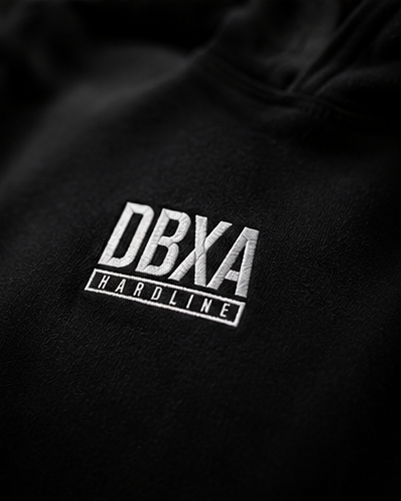 Close-up of DBXA Hardline chest embroidery on the black Corestrike Hoodie