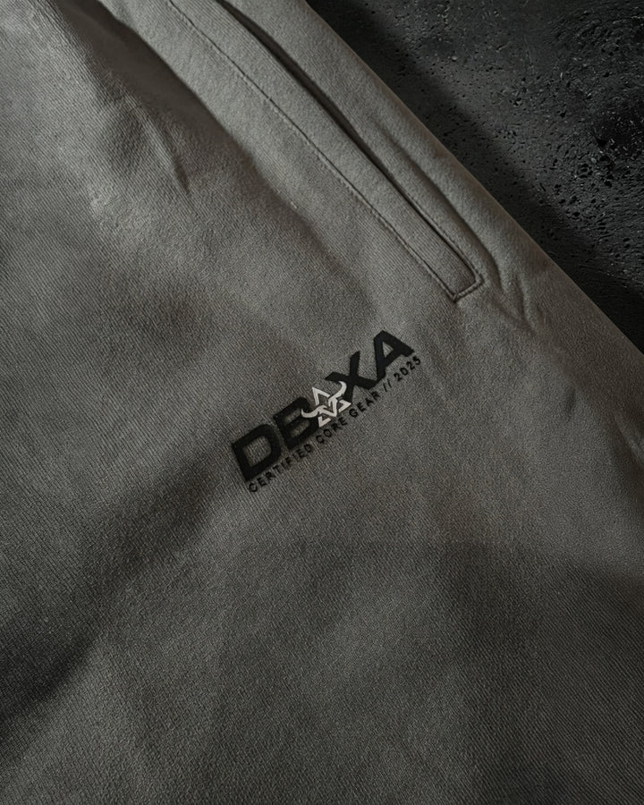 Close-up of a gray pants pocket area with a brand logo on a tdark gray pair of pants