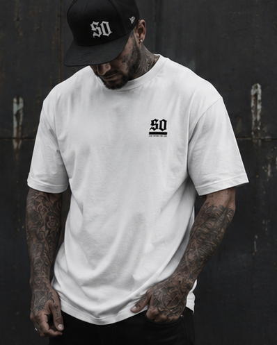 Tattooed male model wearing a white Society Outlaw curved hem tee and black SO cap