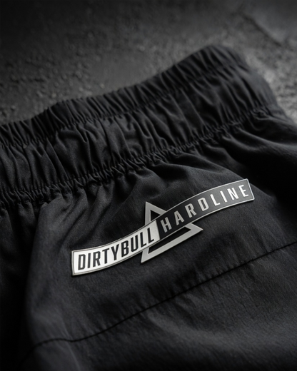 Black shorts with 'DIRTYBULL HARDLINE' logo on a textured surface
