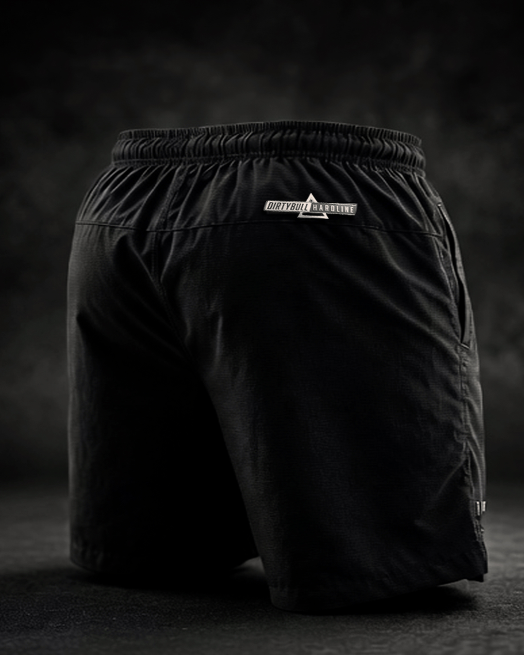 Black shorts with a brand logo on a dark background