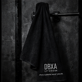 Black DBXA gym towel hanging from a squat rack