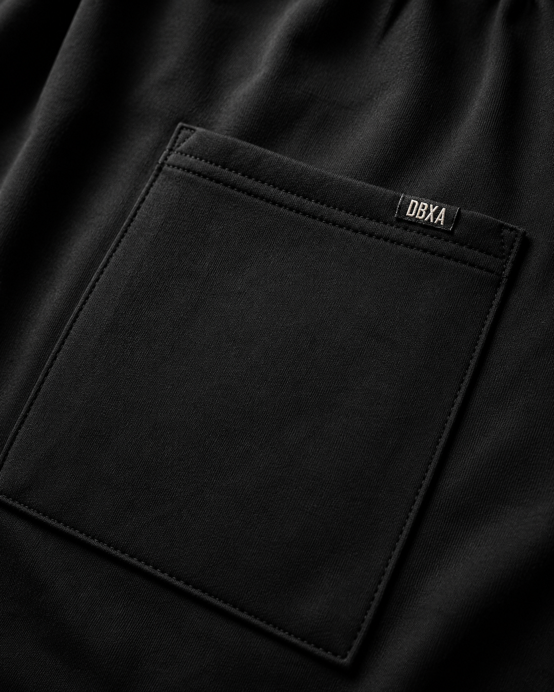 Close-up of a black pocket with a brand label on a dark background