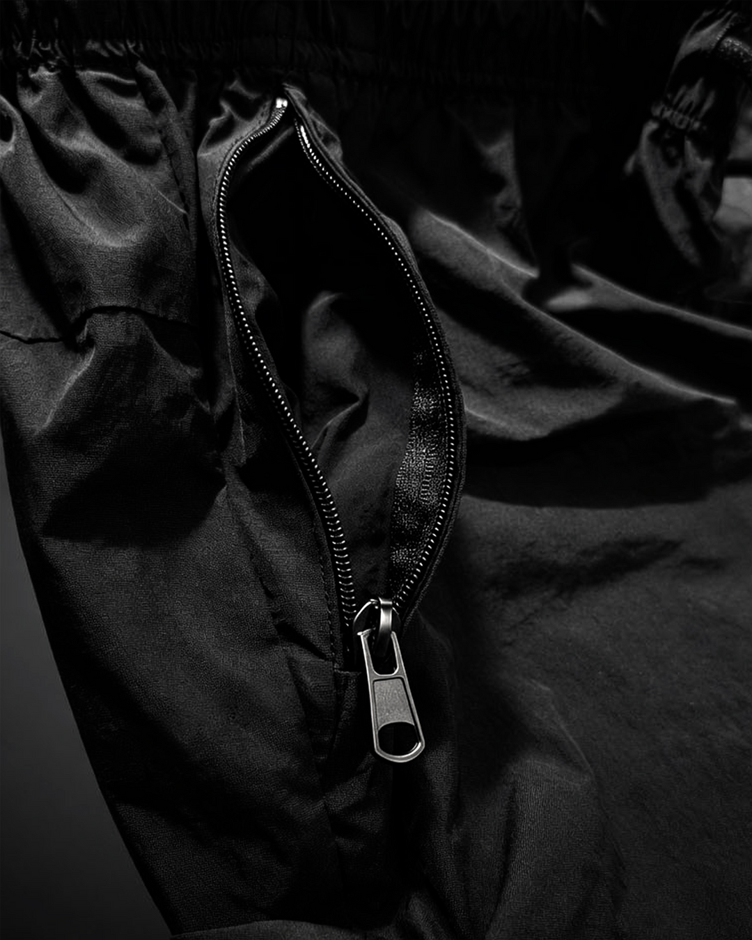 Close-up of a black shorts with a zipper on a dark background