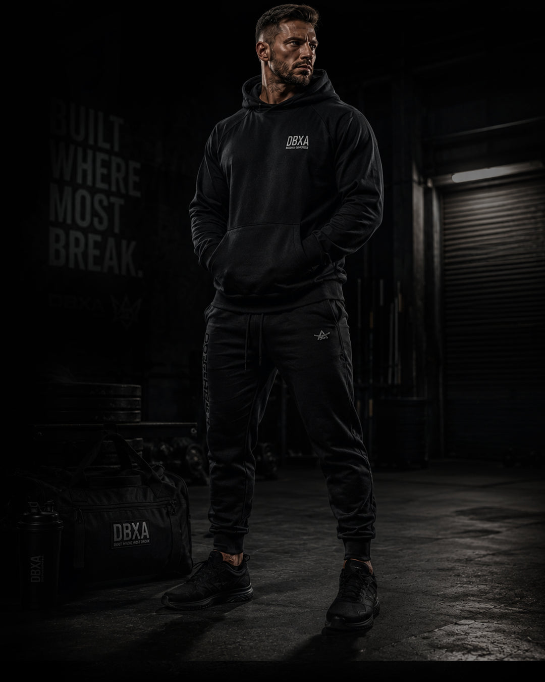 Man wearing a black hoodie and pants with &