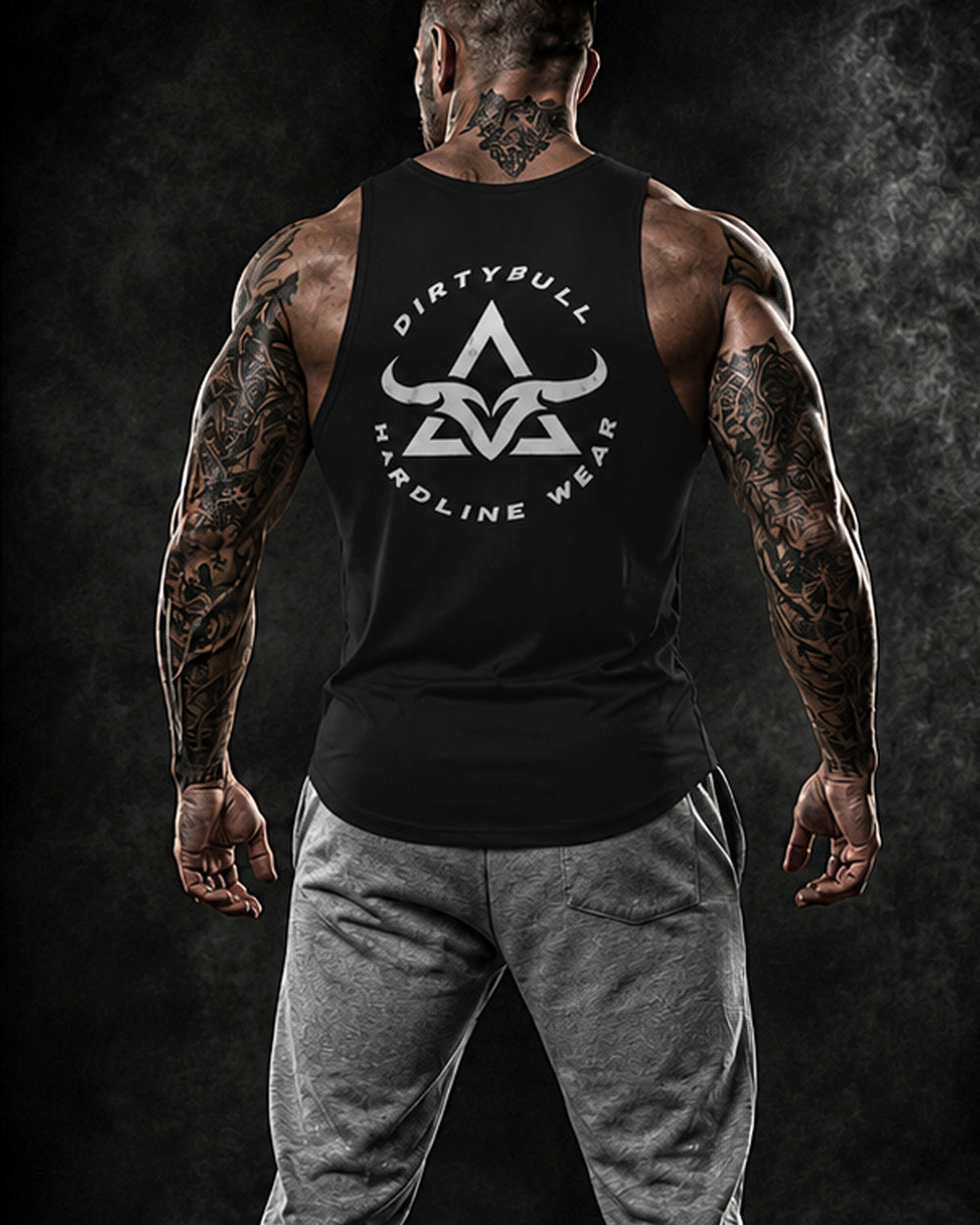 Man wearing a black tank top with 'Dirty Bull Hardline Wear' logo on a dark background