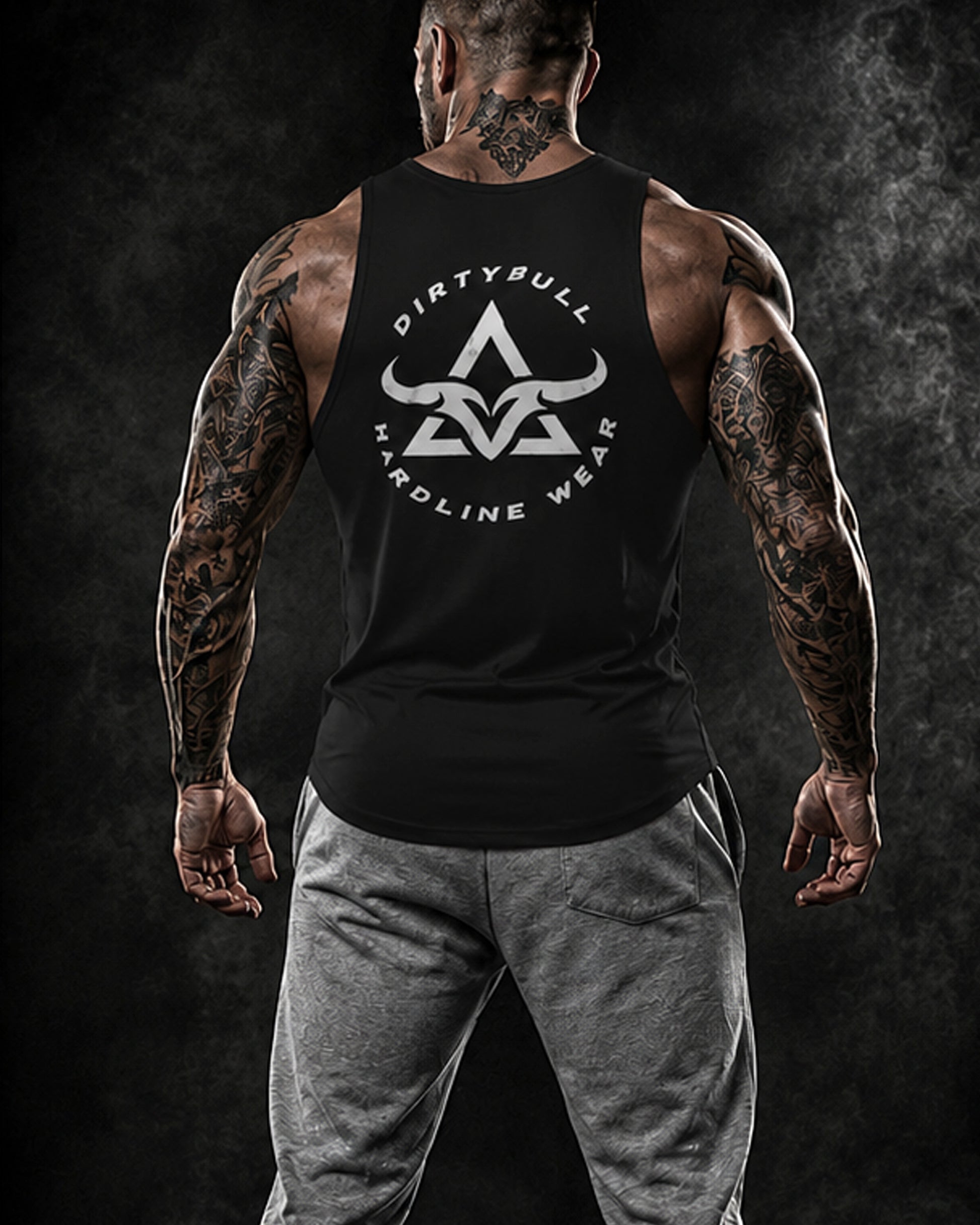 Man wearing a black tank top with 'Dirty Bull Hardline Wear' logo on a dark background