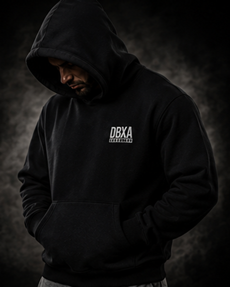 Person wearing a black hoodie with DBXA logo on a dark background