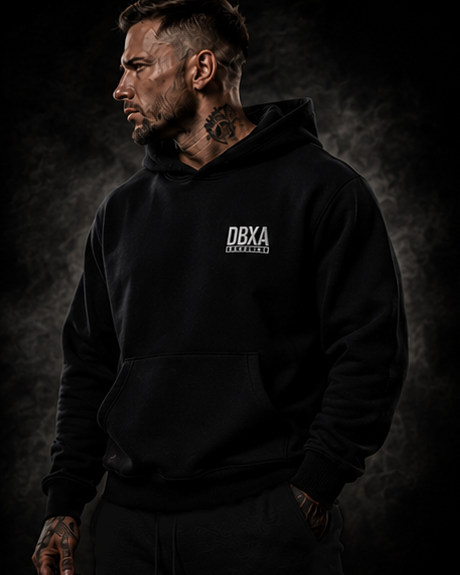Man wearing a black hoodie with DBXA logo against a dark background