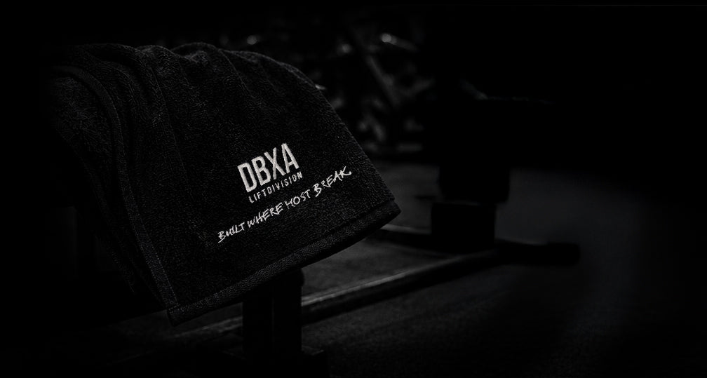 Black DBXA Lift Division gym towel draped over a training bench