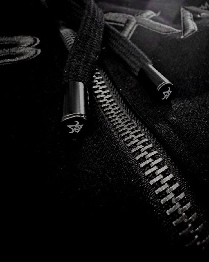 Close-up of black drawcords and silver zip hardware on the DBXA Ironveil hoodie.