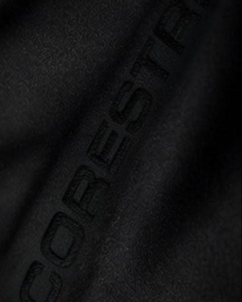 Close-up of CORESTRIKE embroidery on black training pants