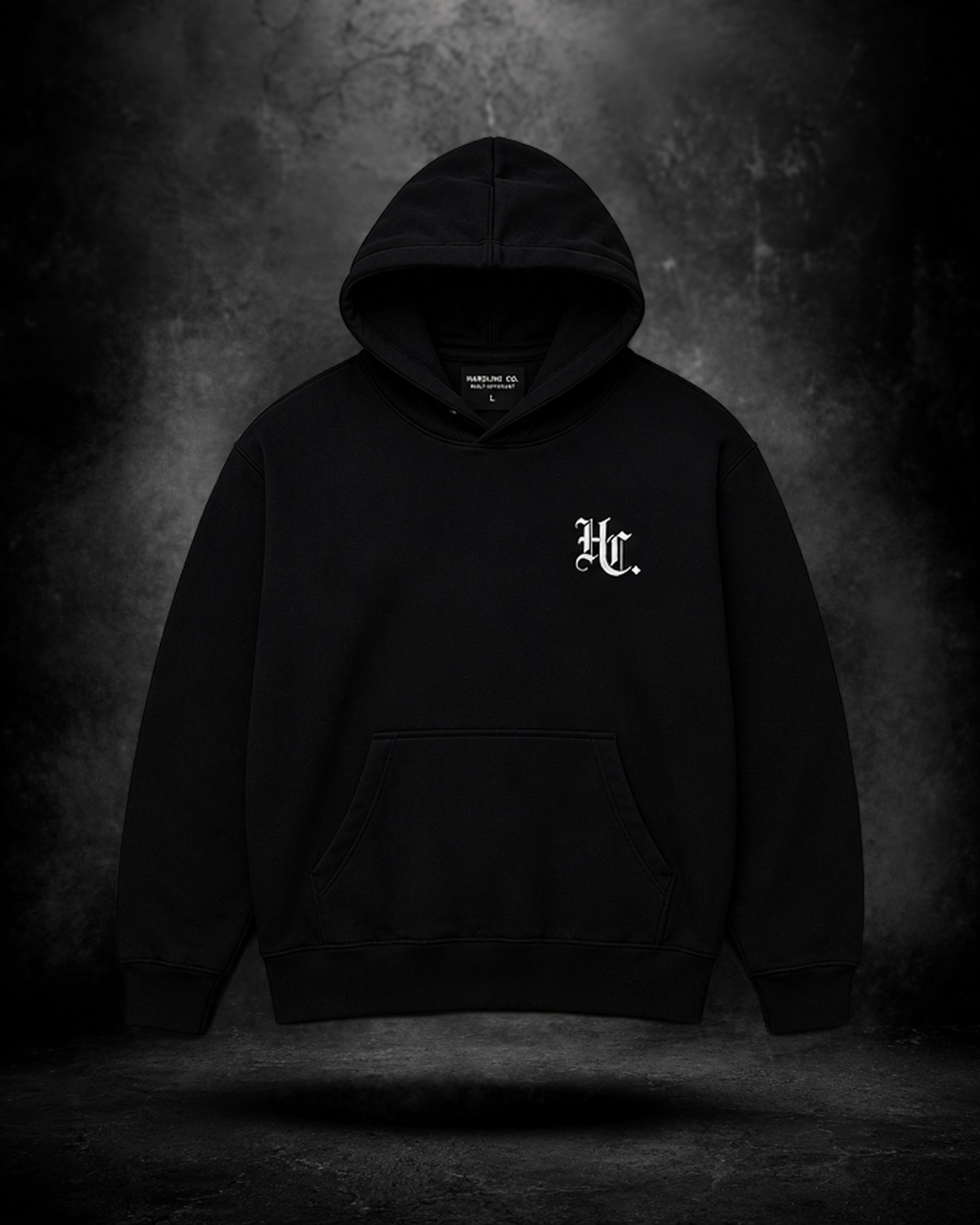Black hoodie with a logo on the chest against a dark background