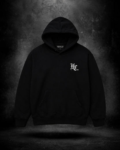 Black hoodie with a logo on the chest against a dark background