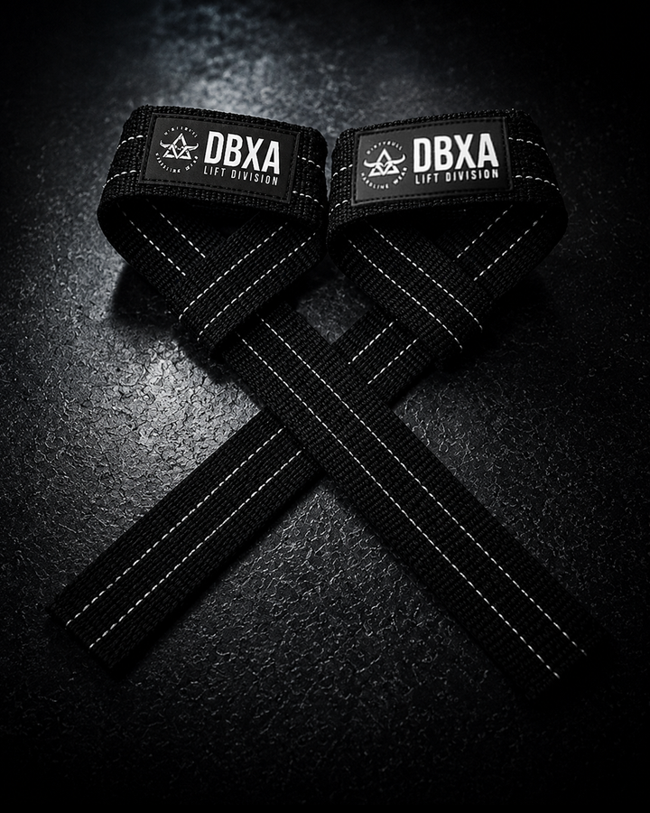 Black DBXA lifting straps crossed on a dark surface