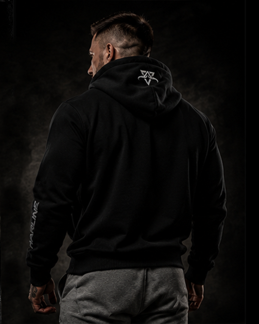 Person wearing a black hoodie with a logo on the back against a dark background