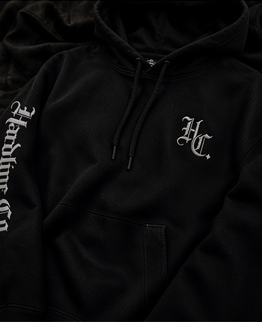 Close-up of the black Hardline Co. Hoodie chest and sleeve embroidery
