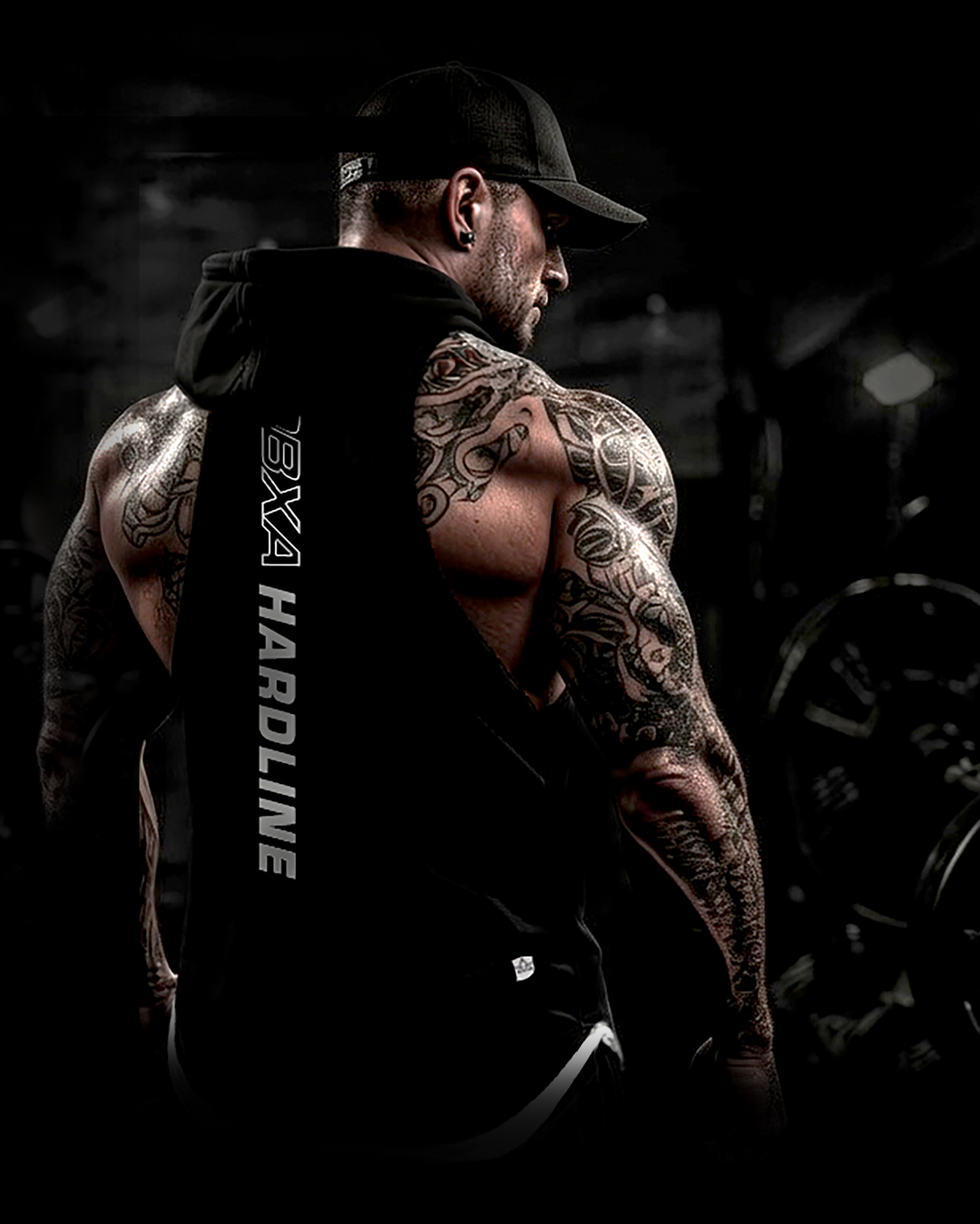 Muscular man wearing a black DBXA Ironcore Hooded Tank showing the vertical back print