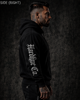 Man wearing a black hoodie with text on the side against a dark background